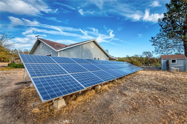 view of side of home featuring a storage shed and solar panels