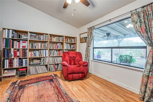 living area with ceiling fan, hardwood / wood-style floors, and lofted ceiling