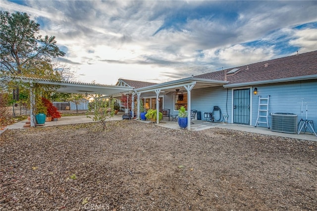 rear view of property with a pergola, central AC unit, and a patio area