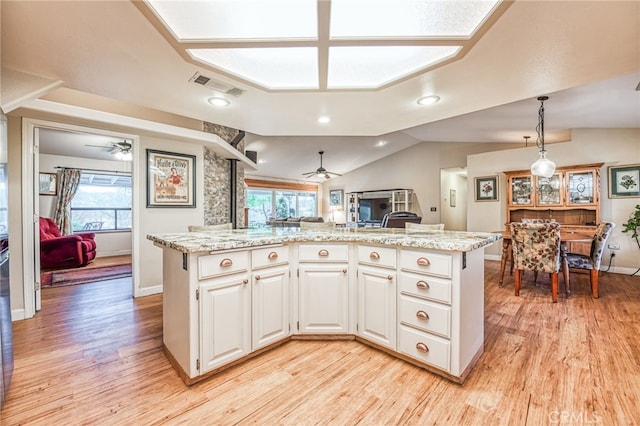 kitchen featuring plenty of natural light, an island with sink, and vaulted ceiling