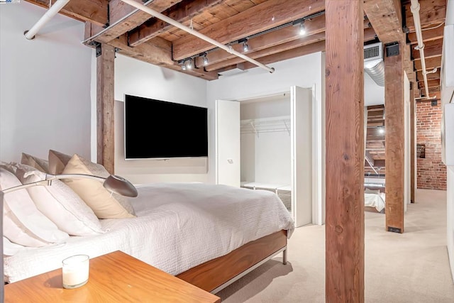 carpeted bedroom with beam ceiling, track lighting, wooden ceiling, and brick wall