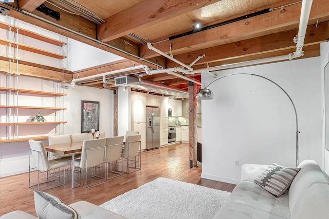 basement featuring stainless steel fridge and light hardwood / wood-style floors