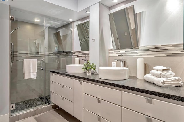 bathroom with tasteful backsplash, vanity, and an enclosed shower