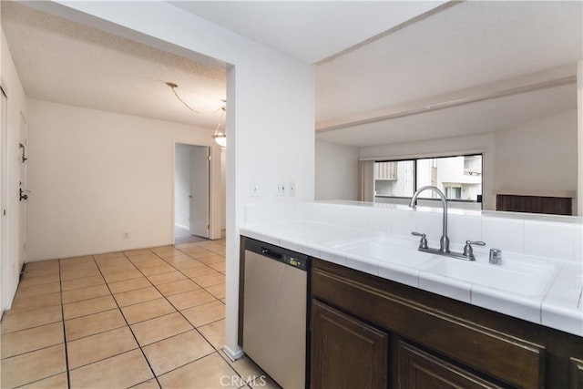 kitchen featuring dark brown cabinetry, dishwasher, sink, tile countertops, and light tile patterned flooring