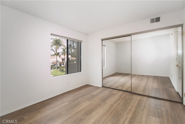 unfurnished bedroom featuring hardwood / wood-style floors and a closet