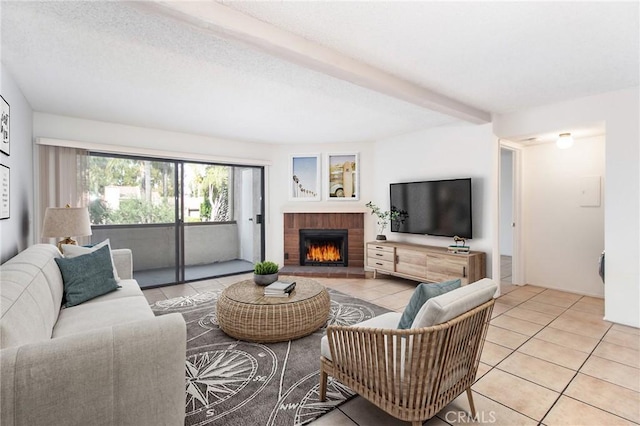 living room with a textured ceiling, beam ceiling, light tile patterned floors, and a fireplace