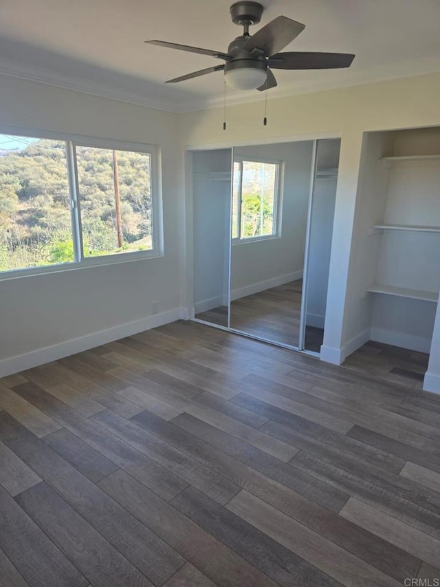 unfurnished bedroom featuring ceiling fan and dark hardwood / wood-style flooring