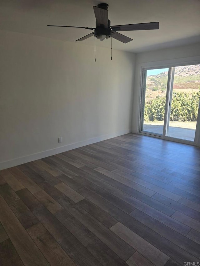 empty room with ceiling fan and dark hardwood / wood-style flooring