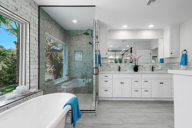 bathroom with vanity and shower with separate bathtub