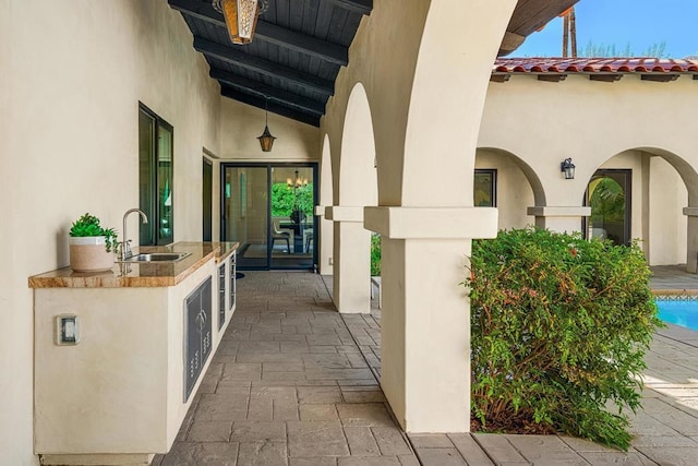 exterior space featuring area for grilling, sink, and wine cooler