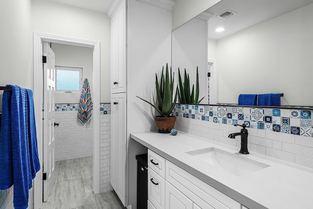 bathroom with vanity and tile walls