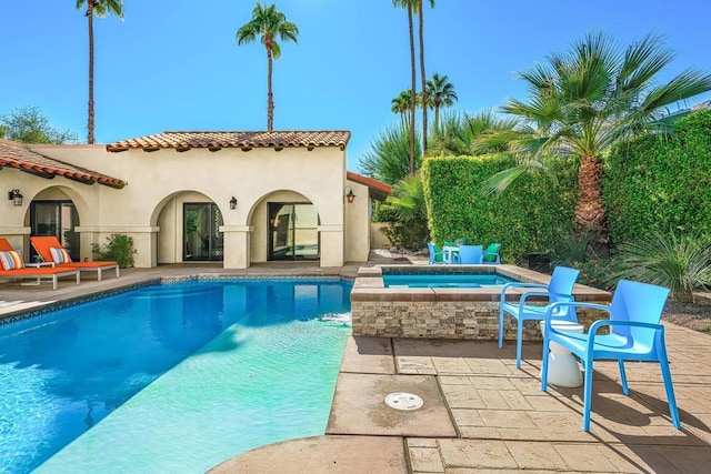 view of pool with a patio area and an in ground hot tub