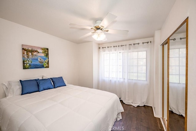 bedroom with a closet, dark wood-style floors, and a ceiling fan