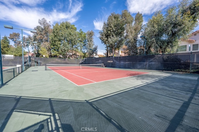 view of tennis court with basketball hoop