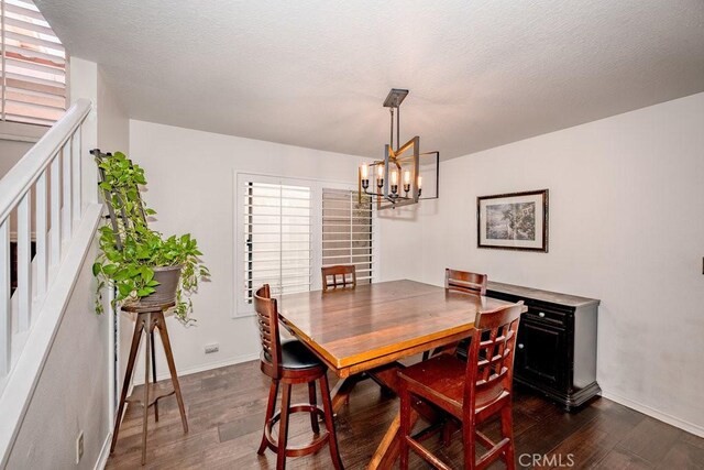 dining room featuring a chandelier, a textured ceiling, and dark hardwood / wood-style floors