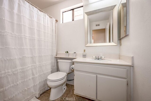 bathroom featuring tile patterned flooring, vanity, a shower with shower curtain, and toilet