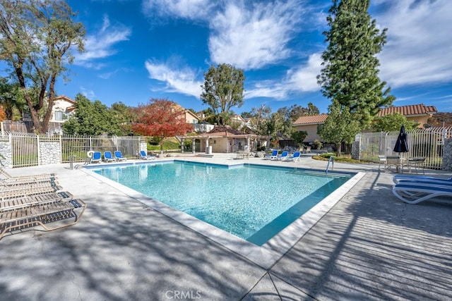 community pool featuring a patio and fence