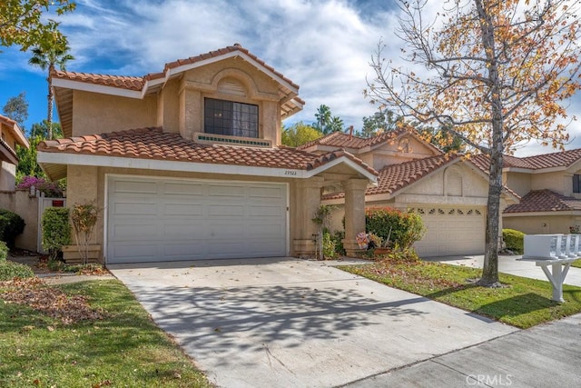 mediterranean / spanish-style home featuring concrete driveway, a tile roof, and stucco siding