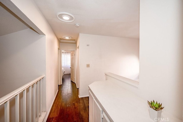 hallway with baseboards and dark wood-type flooring