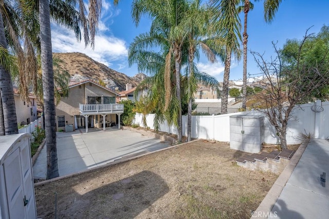 view of yard with a mountain view, a fenced backyard, and a patio area