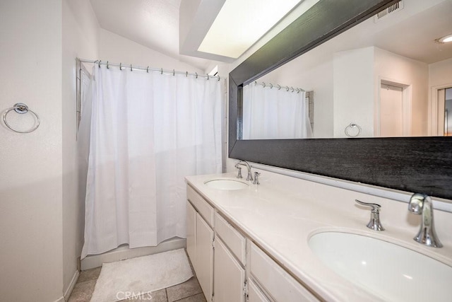 bathroom with tile patterned floors, vanity, vaulted ceiling, and shower / tub combo with curtain