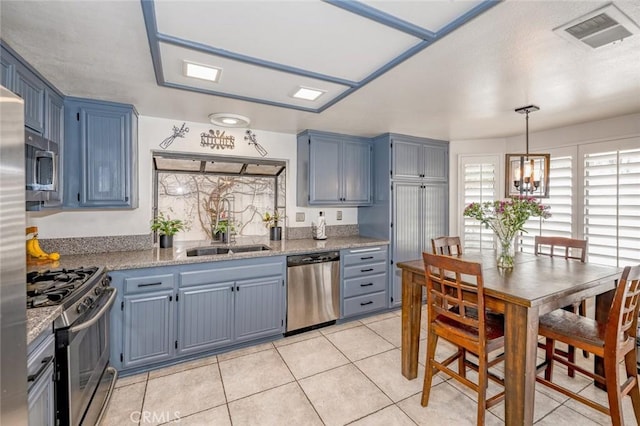 kitchen with visible vents, light tile patterned flooring, stainless steel appliances, blue cabinets, and a sink