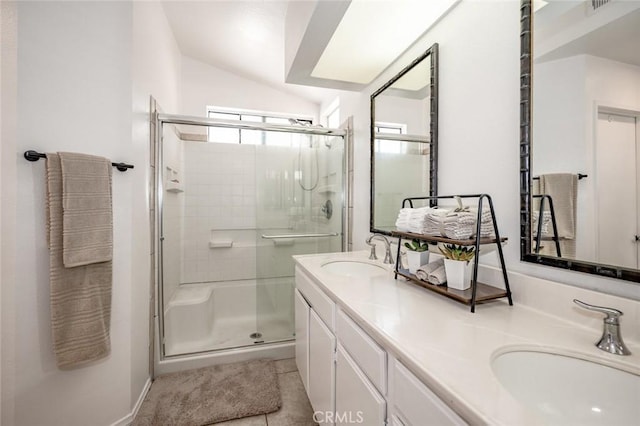 full bath featuring tile patterned flooring, vaulted ceiling, a stall shower, and a sink