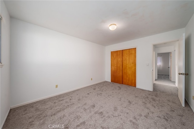 unfurnished bedroom with carpet floors and a closet