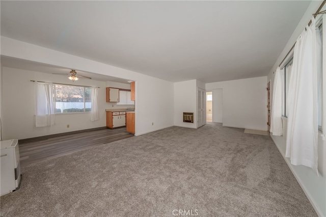 unfurnished living room featuring light carpet and ceiling fan