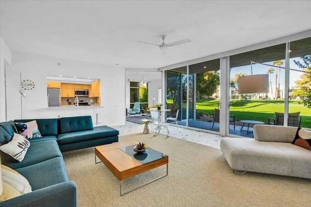 living room with light carpet, expansive windows, and ceiling fan