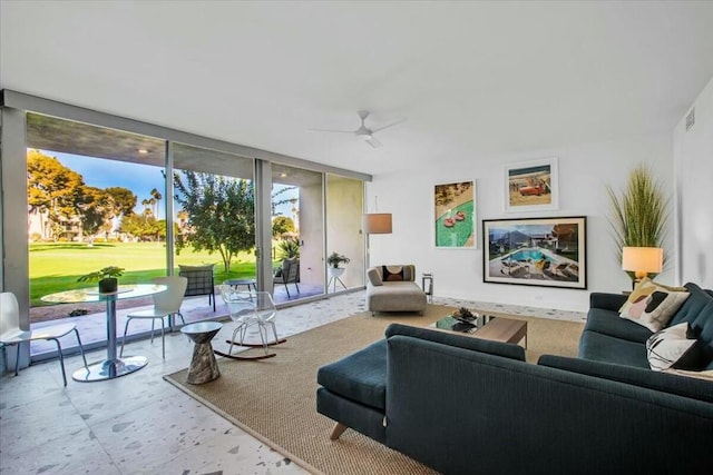 living room featuring ceiling fan and a wall of windows