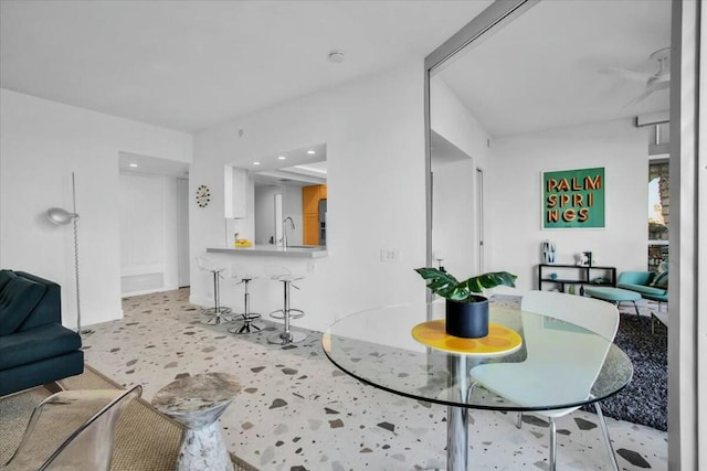 dining room featuring ceiling fan and sink