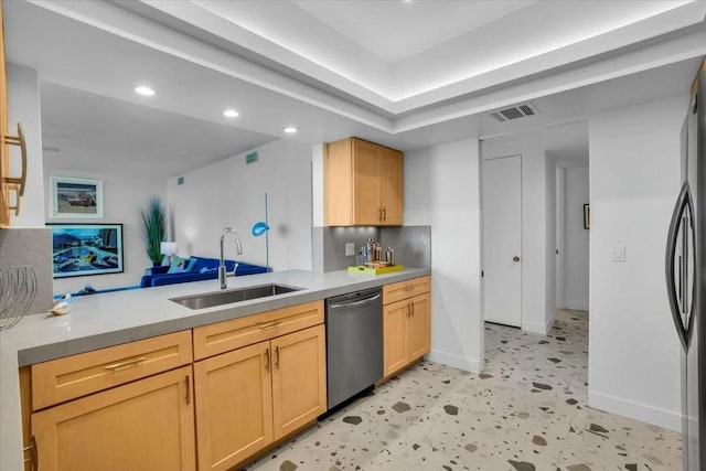 kitchen with dishwasher, light brown cabinetry, and sink