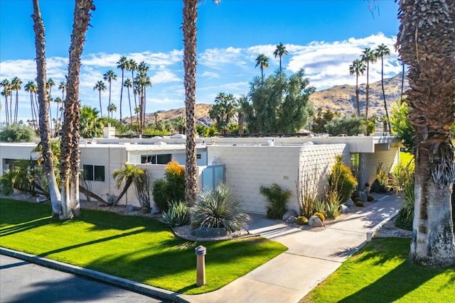 view of front of property with a front lawn and a mountain view