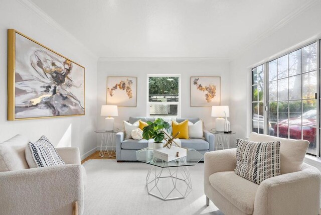 living room with wood-type flooring, a wealth of natural light, and crown molding