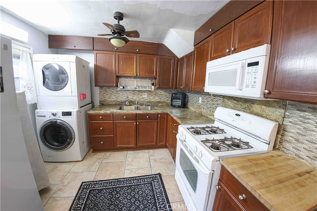 kitchen featuring ceiling fan, sink, backsplash, stacked washer / dryer, and white appliances