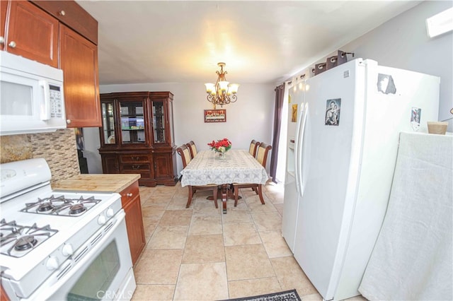 kitchen featuring a notable chandelier, white appliances, and decorative light fixtures