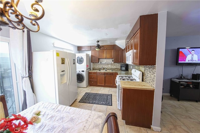 kitchen featuring decorative backsplash, white appliances, ceiling fan, light tile patterned floors, and stacked washer / dryer