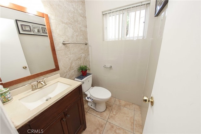 bathroom with tile patterned floors, vanity, tile walls, and toilet