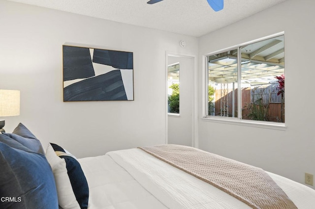 bedroom with ceiling fan and a textured ceiling