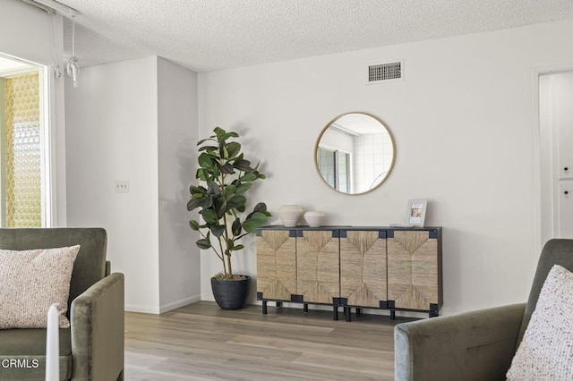 living area with a textured ceiling and hardwood / wood-style flooring