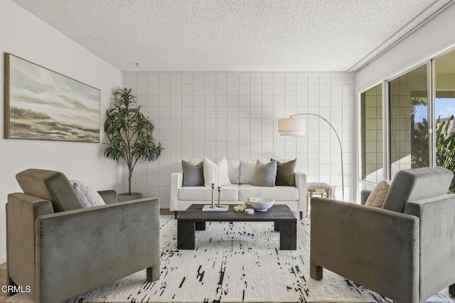 living room with a textured ceiling and tile walls