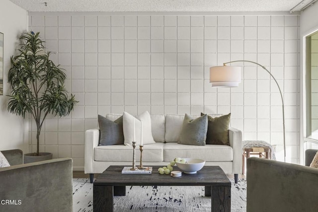 living room with hardwood / wood-style floors, a textured ceiling, and tile walls