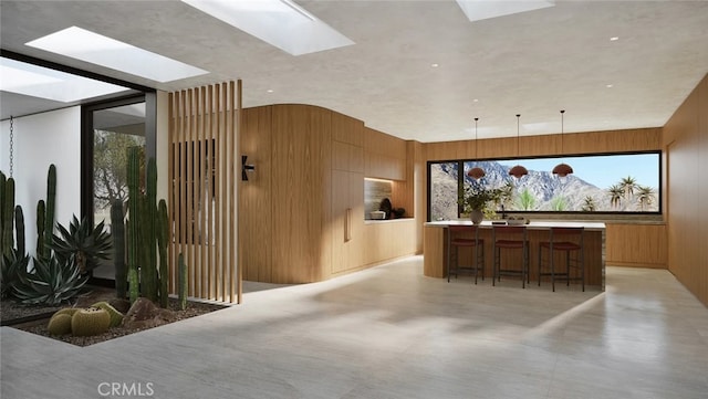 home theater with a skylight and wood walls