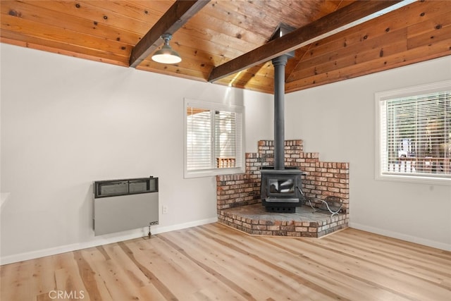 unfurnished living room with beam ceiling, heating unit, and a wealth of natural light