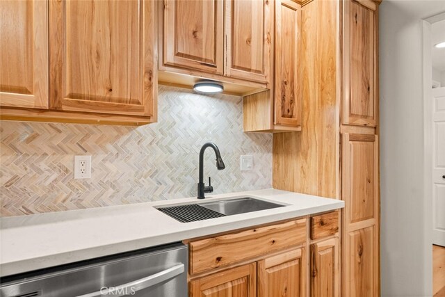 kitchen featuring dishwasher, decorative backsplash, and sink