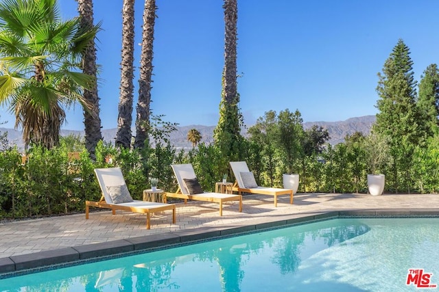 view of swimming pool featuring a mountain view and a patio