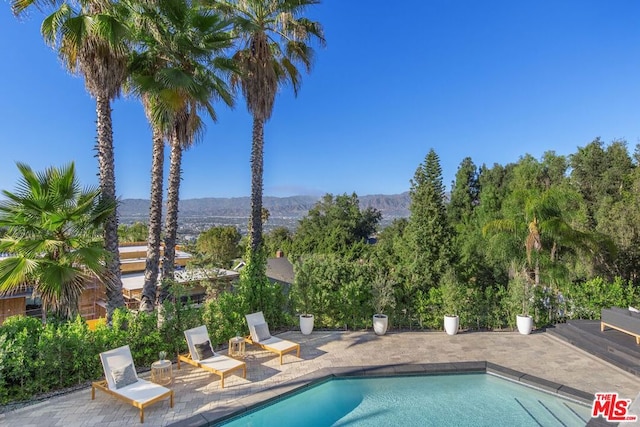 view of pool featuring a mountain view and a patio