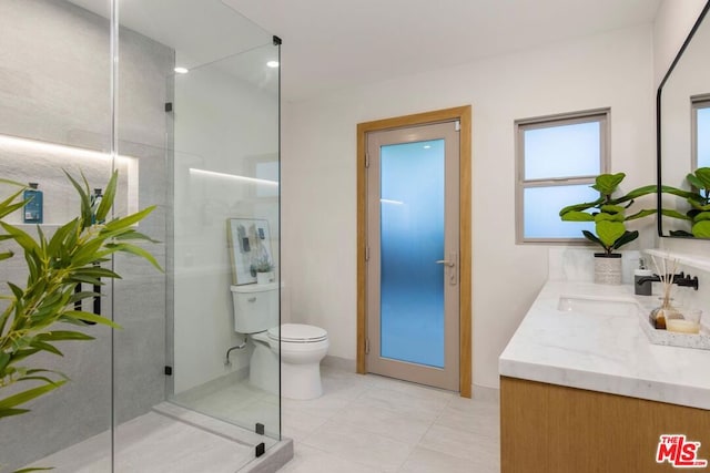 bathroom with tile patterned floors, vanity, an enclosed shower, and toilet