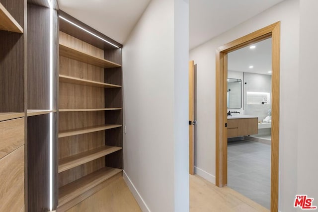 spacious closet featuring light tile patterned floors and sink